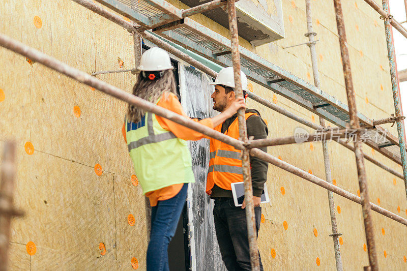 脚手架上的女建筑师和建筑工人