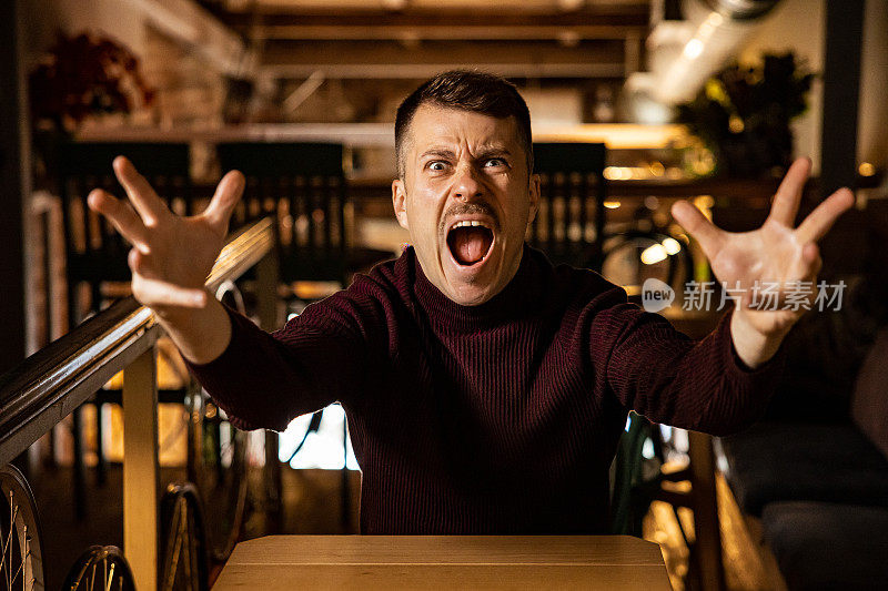 白人男子做鬼脸和手势，表达消极的情绪和愤怒