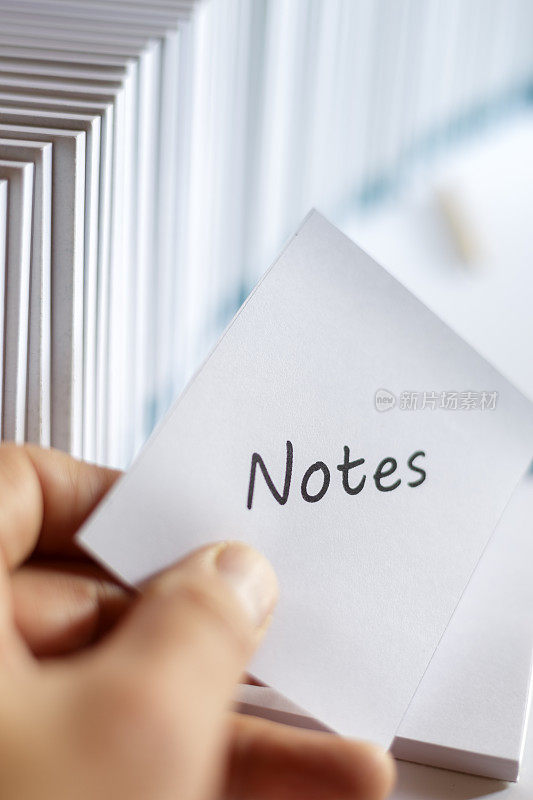 手持写有“notes”字样的记事本