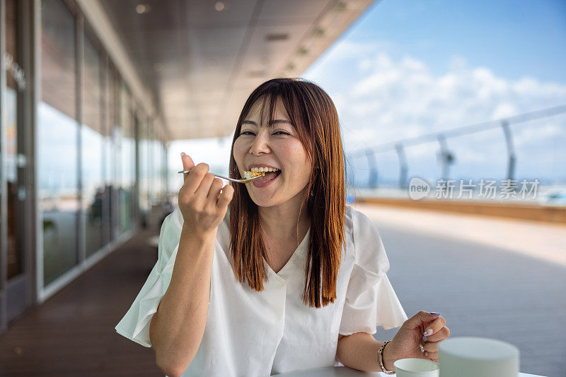 一位女士在户外咖啡馆吃咖喱午餐