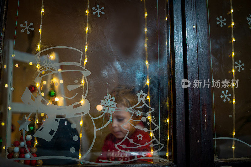 圣诞夜，小兴奋的孩子在等待圣诞老人。在新年的夜晚，学龄前的男孩望着窗户，希望魔法和礼物