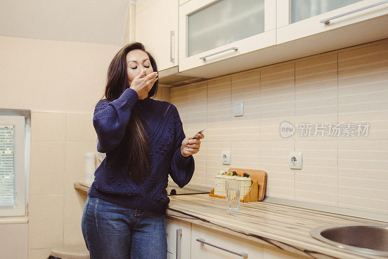 美丽的亚洲妇女在家里吃药