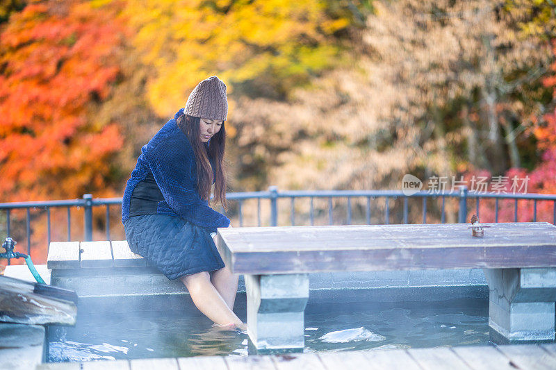 秋天，一名女子在温泉小镇的免费公共温泉足浴中泡脚