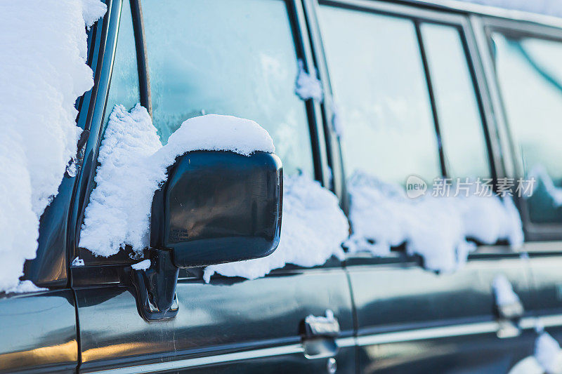 汽车镜子特写。雪下的汽车。冬天的天气。气候。风暴。运输