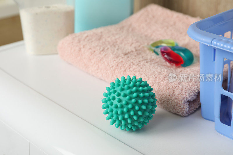 洗衣机上的绿松石干衣球、清洁剂和毛巾