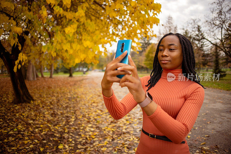 现代黑人女性在公园用手机自拍