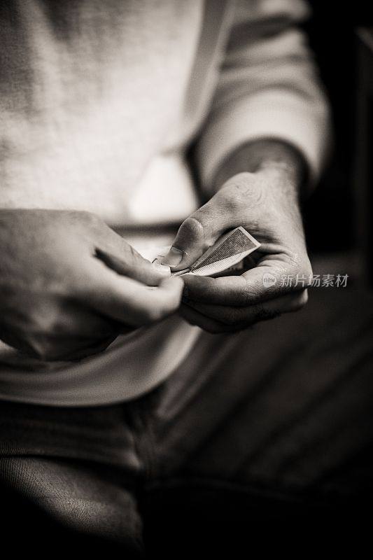 一个成年男子折叠一张纸的灰度照片