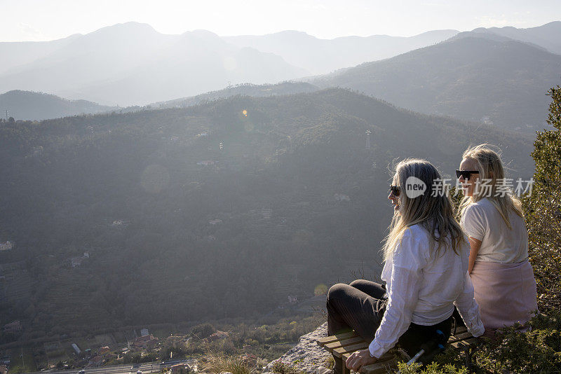 老年女徒步旅行者在远山的山顶上放松