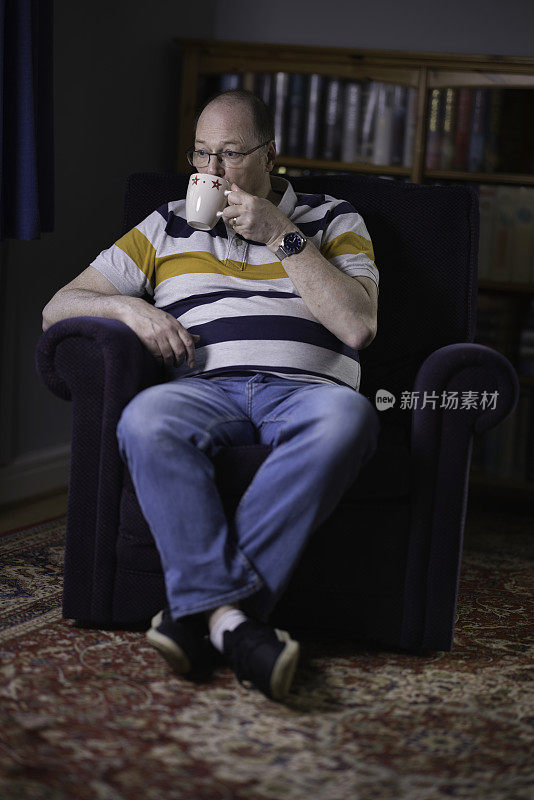 一个60岁的白人男人正在喝一杯茶