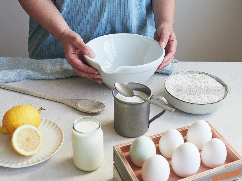 手放在碗上准备煮鸡蛋的人的局部视图