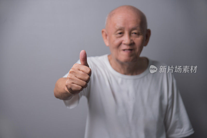 穿着白衬衫的亚洲秃顶老人竖起大拇指