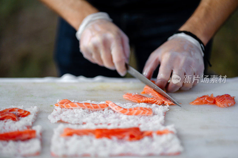 寿司厨师正在为社交活动的寿司卷切三文鱼