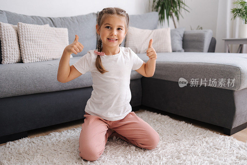 活泼、有活力的小女孩玩得很开心。客厅。孩子坐在地毯上。