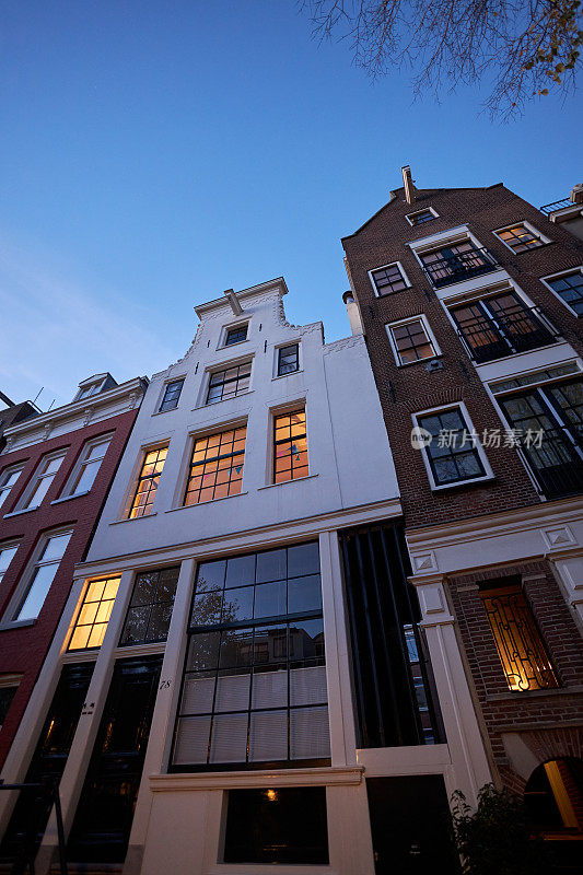 黄昏时分，阿姆斯特丹的城市街道和白色运河房屋