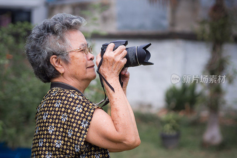 老妇人用数码相机拍照