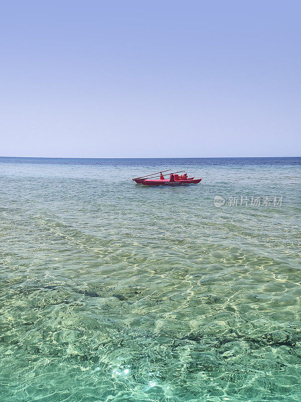 一艘红色的救援船停在透明清澈的西西里岛海上