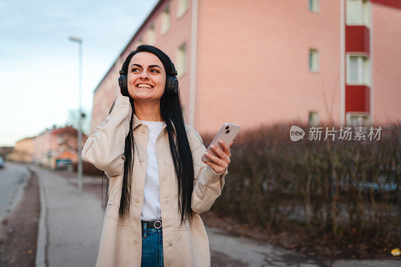 微笑的年轻女子在户外玩手机