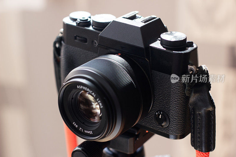 黑色复古设计的相机安装在三脚架上，用于拍摄照片或视频。