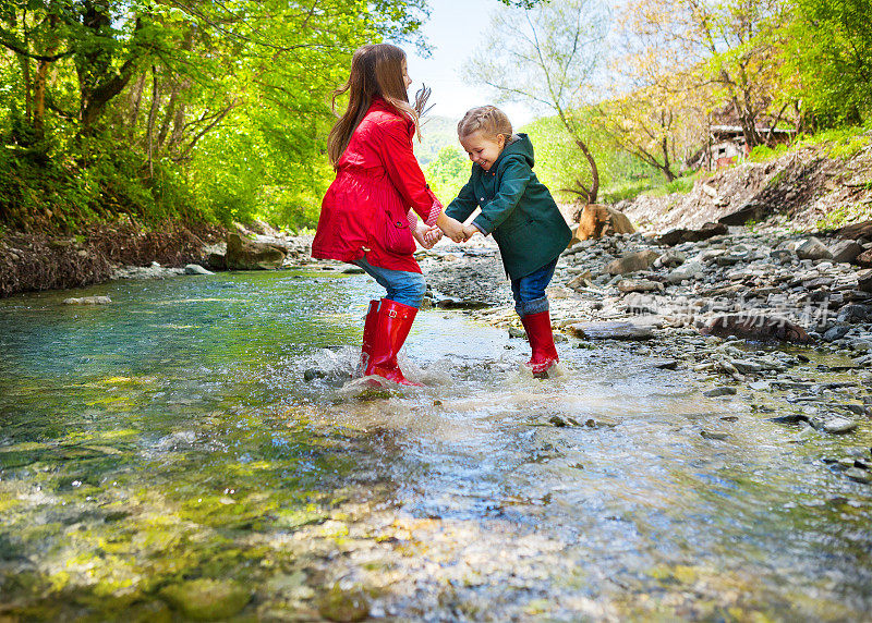 孩子们穿着雨靴跳进山里的河里