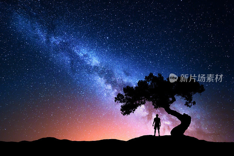 银河，树和孤独的人的剪影。晚上的风景