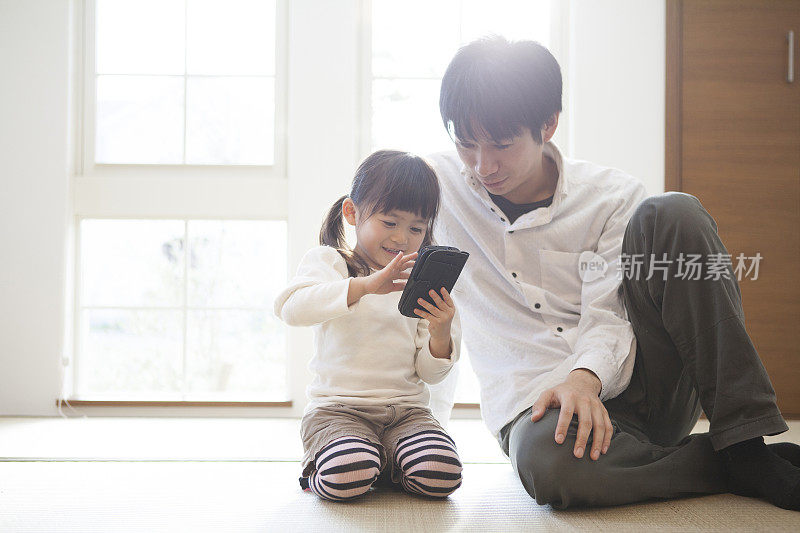 日本父女在玩手机