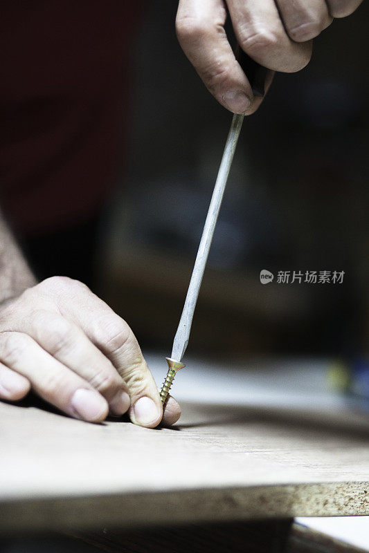 木匠用螺丝刀和螺丝把木板连接起来