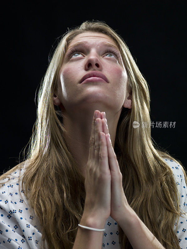 年轻的金发女人在祈祷