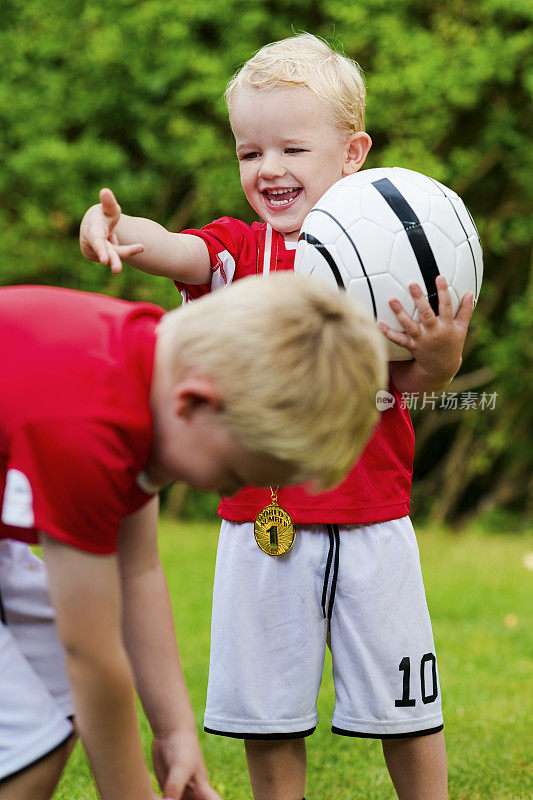 两个穿着足球服的男孩玩得很开心