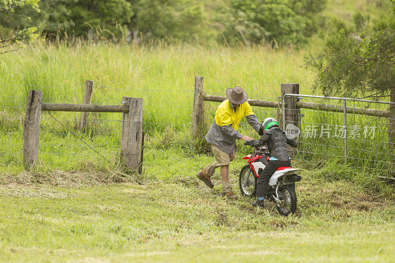 农民在农场帮助陷入沼泽的越野自行车骑手