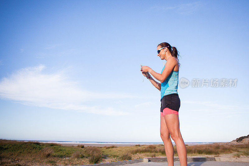 女运动员在用智能手机查看她的跑步数据