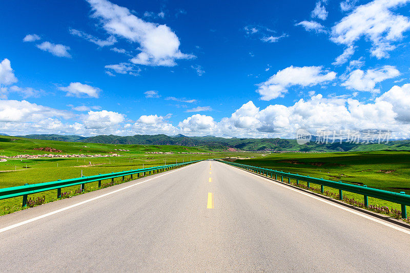 西藏高原的道路、草地和天空