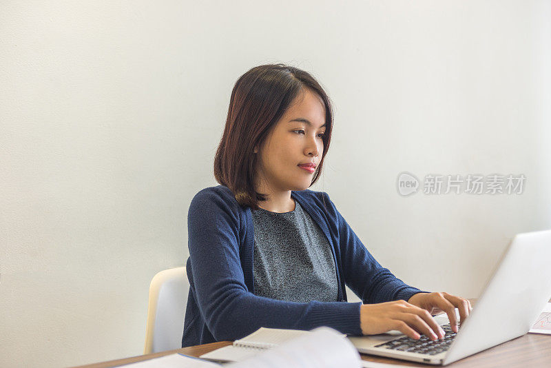 亚洲女商人一边打字一边回复客户的邮件