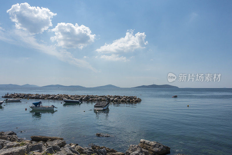 坠落的海岸线场景与防波堤和船只