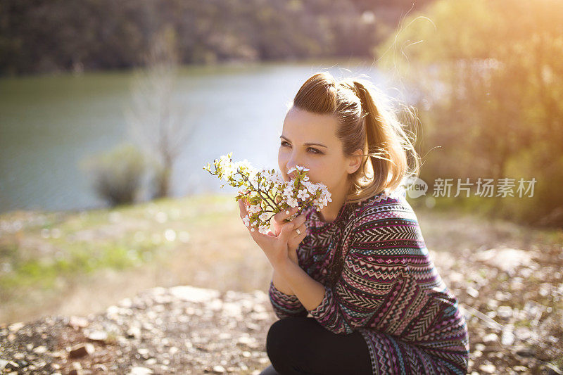 女人带着春天的花在山上的湖