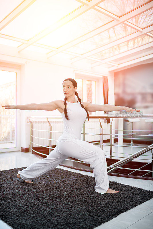 穿着白色的女人练习瑜伽-战士2姿势