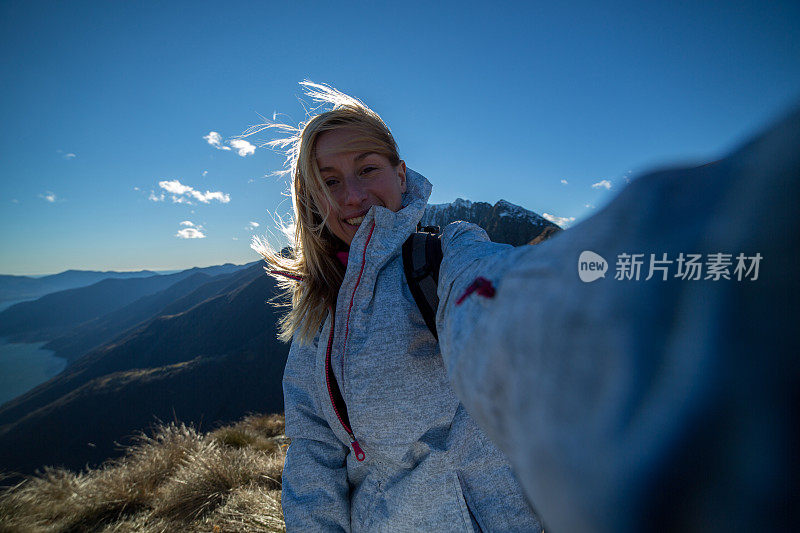 一名年轻女子在登山时用手机自拍