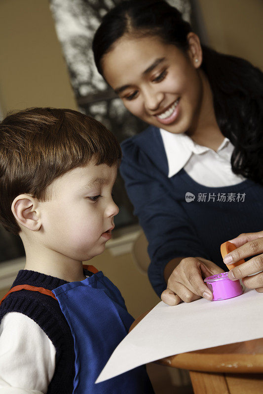 帮助孩子用手指画的幼儿园老师或日托工人