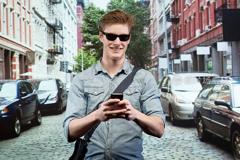 微笑的男人使用手机在城市前面