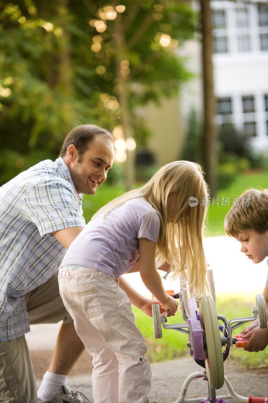 孩子女孩和父亲修理自行车夏天的生活方式