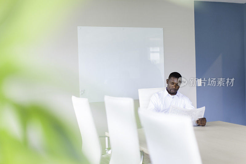 一个非洲商人坐在会议室的桌子旁