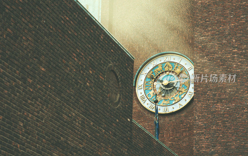 美丽的十二宫时钟挂在奥斯陆一座建筑的砖墙上，阳光明媚