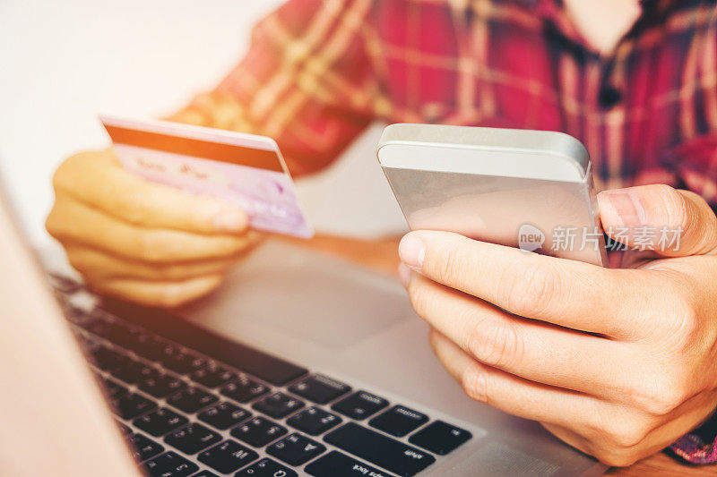 持有信用卡和使用手机的人持有信用卡在网上购物