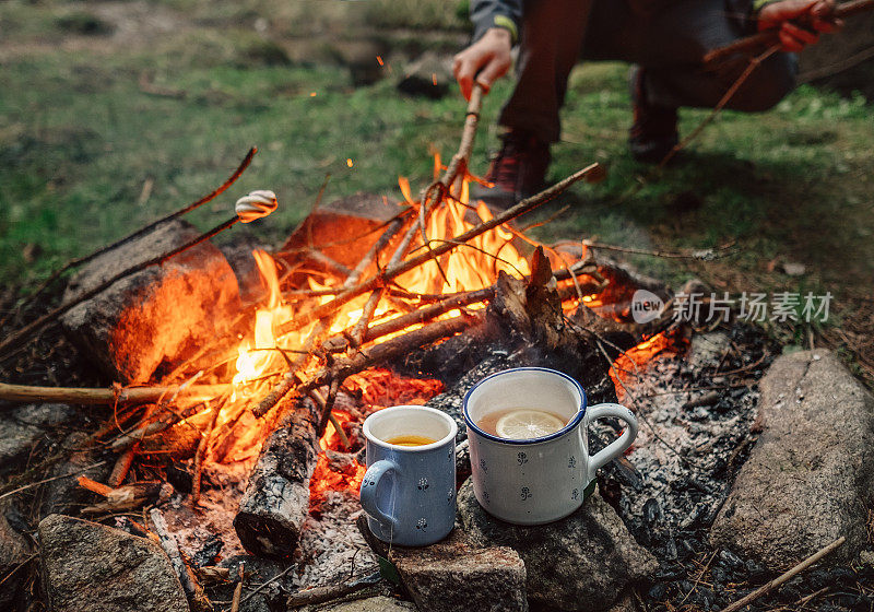 两个大杯子，配上热茶和柠檬，放在篝火旁