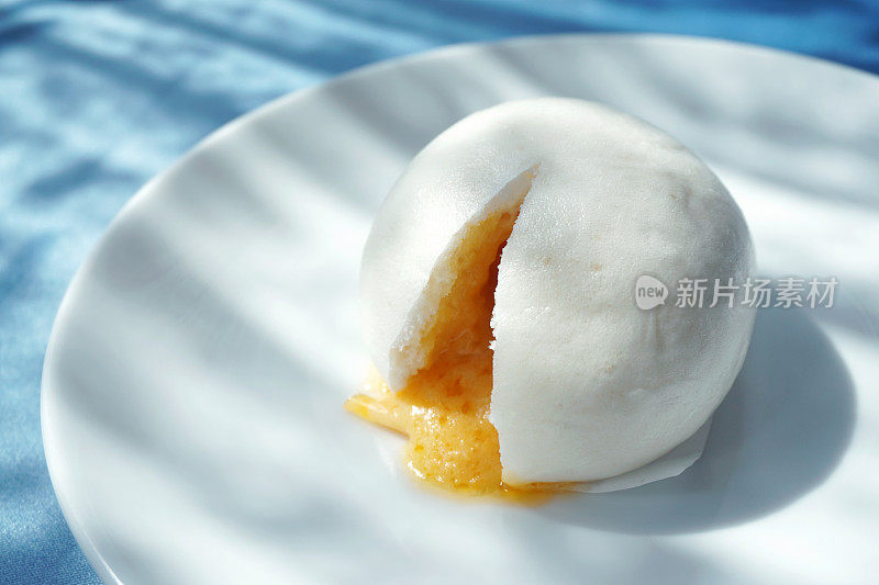 特写中国馒头或中国蛋黄蛋糊面包在白色盘子-传统的中国点心，选择焦点。