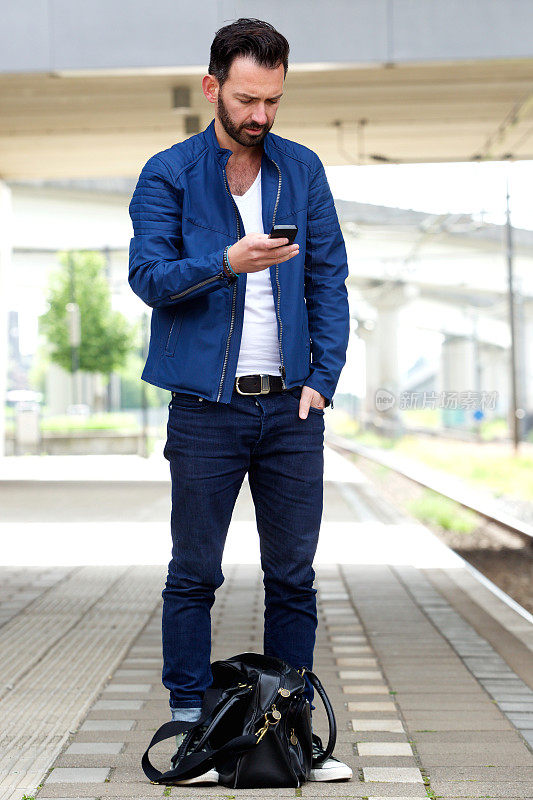 一名男子在火车站使用手机
