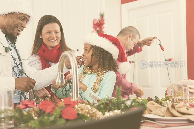 多民族家庭在家庭厨房为圣诞节装饰。