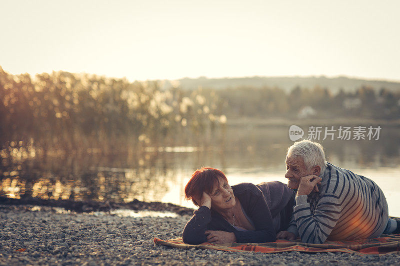 一对老年夫妇在湖边享受秋日