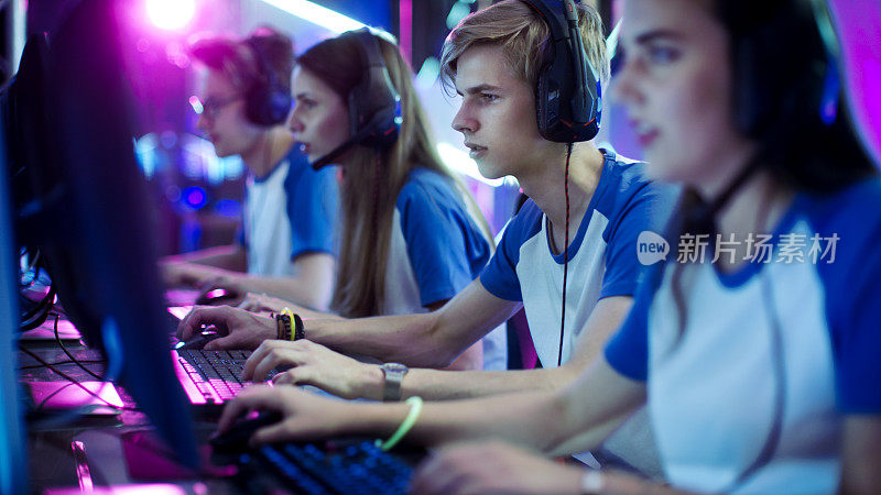 在一场网络游戏锦标赛上玩竞技电子游戏的职业电竞玩家团队。他们使用麦克风。