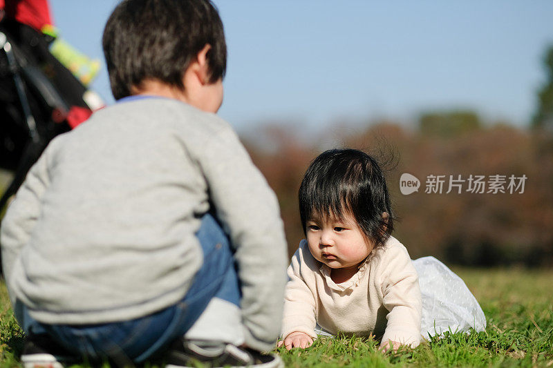 幼童和婴儿在公园草地上玩耍