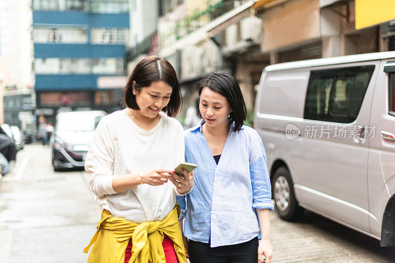 亚洲妇女在街上使用手机